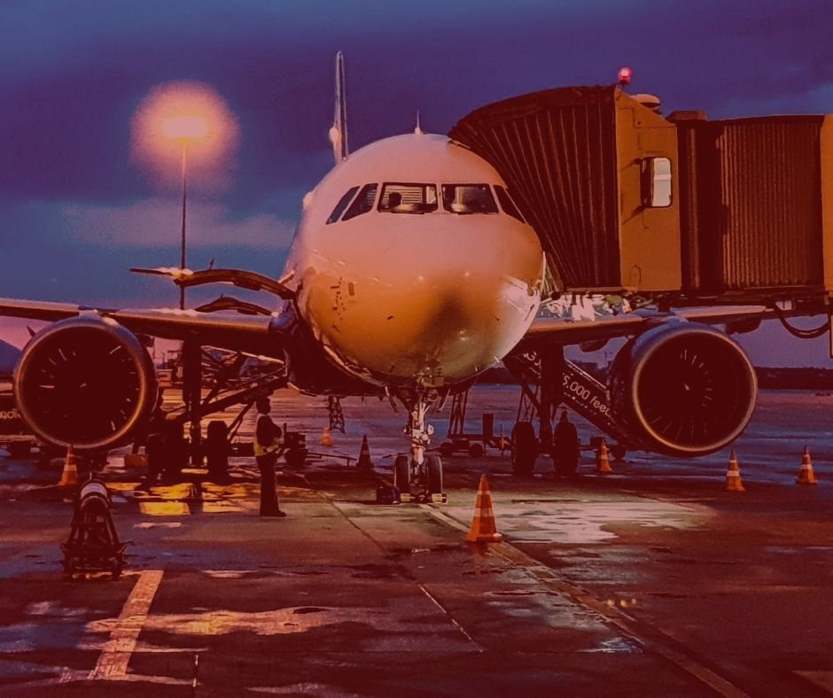 #pratodosverem: Nova lei traz regras para reembolso de passagens aéreas durante pandemia. Na foto, um avião parado no aeroporto, pronto para o embarque. Cores na foto: branco, preto, laranja e azul.