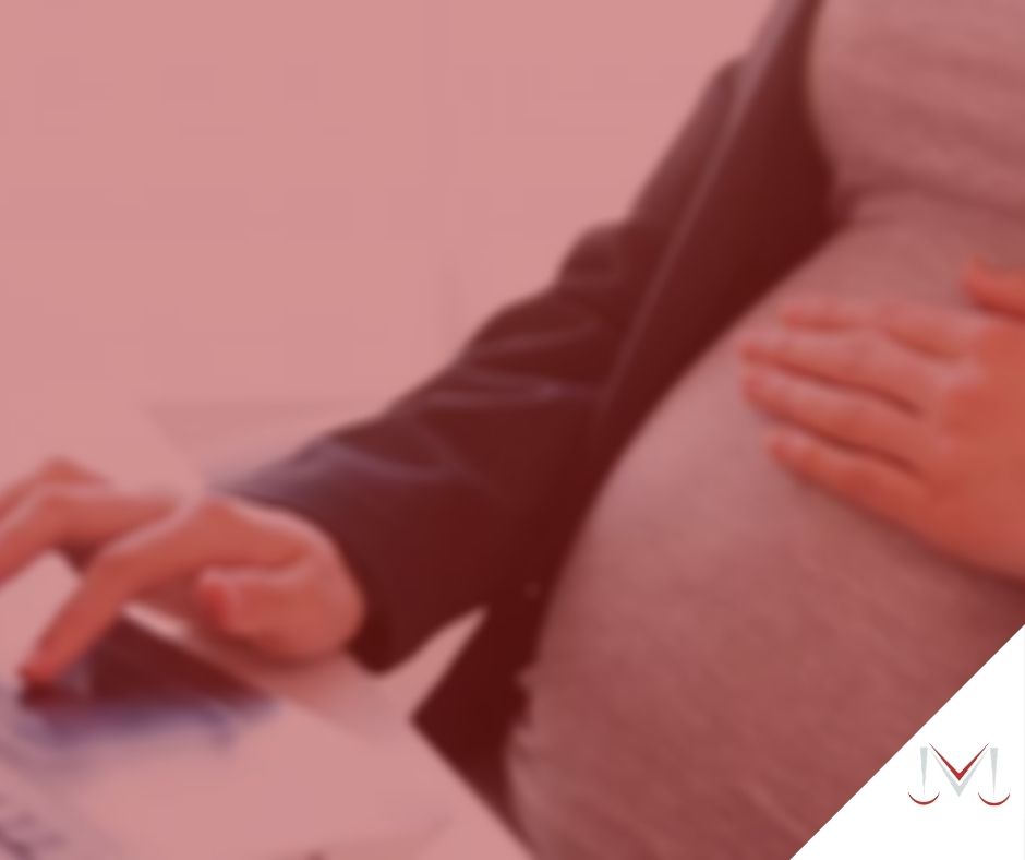 #pratodosverem: post: MEI tem direito à salário-maternidade? Na foto uma mulher grávida esta mexendo no computador. Cores na imagem: vermelho, cinza, preto.