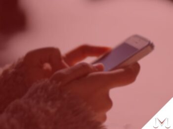 #pratodosverem: artigo: Posso requerer indenização por demissão pelo Whatsapp? - Na foto uma pessoa está mexendo no telefone celular. Cores na imagem: vermelho, branco e azul.