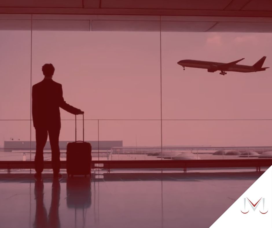 #pratodosverem: artigo: Férias concedidas fora do prazo. Descrição da imagem: um homem está no aeroporto com sua bagagem na mão. Cores na foto: vermelho, cinza, preto e azul. 