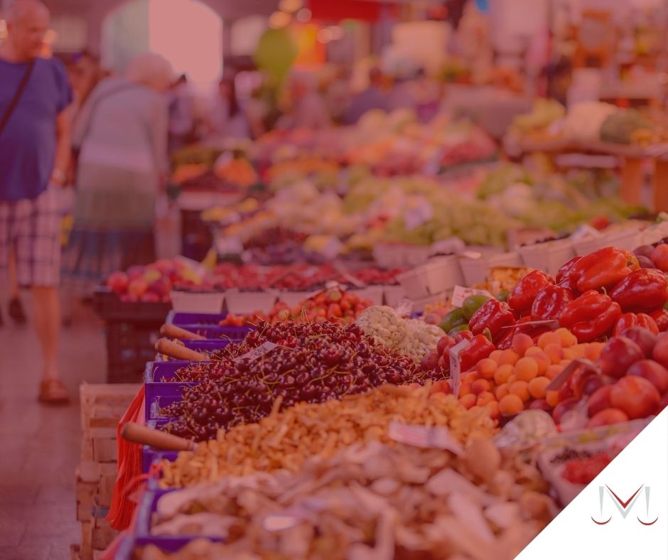 #pratodosverem: artigo: Práticas discriminatórias nas relações de consumo. Descrição da imagem: pessoas realizando compras em um mercado no setor de frutas e verduras. Cores na foto: verde, vermelho, azul, marrom, laranja, amarelo, preto e cinza. 