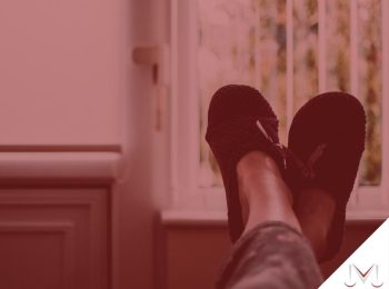 #paratodosverem: artigo: Descanso semanal remunerado. Descrição da imagem: uma pessoa com os pés apoiados no encosto do sofá. Cores na foto: marrom, preto, cinza, vermelho e branco.