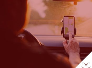 #paratodosverem: artigo: Motorista de aplicativo pode ter vinculo reconhecido? Descrição da imagem: um motorista utilizando o gps do seu celular. Cores na foto: verde, branco, amarelo, vermelho, cinza e preto.
