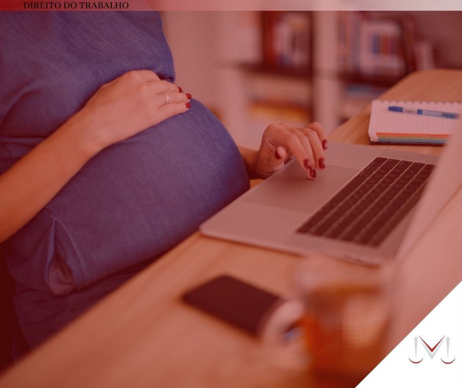 #pratodosverem: artigo: Gestantes podem voltar ao trabalho? Descrição da imagem: uma mulher grávida está digitando no seu notebook. Cores na foto: prata, preto, azul, vermelho, cinza, laranja e branco. 
